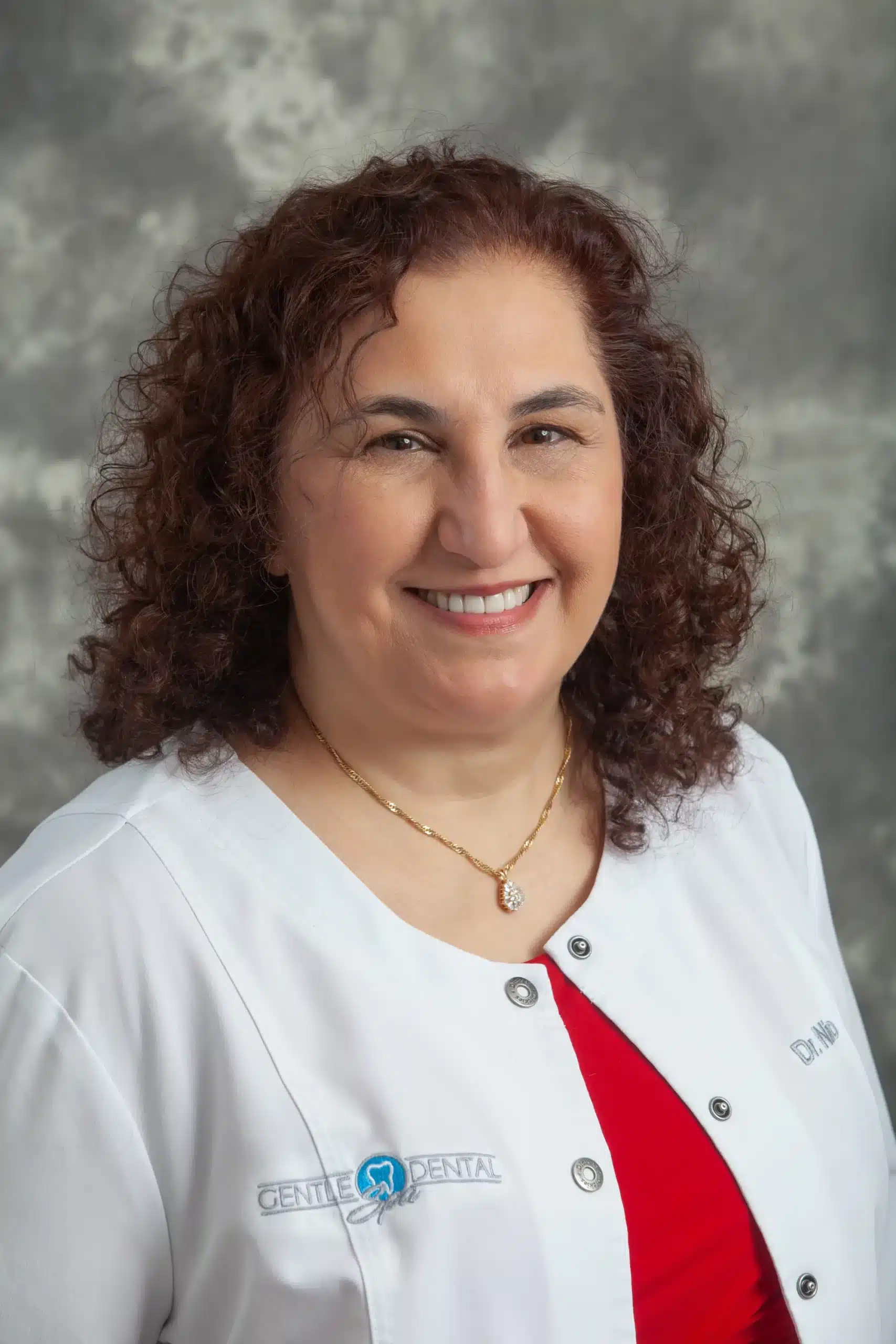 Dr. Jacqueline Niro-Kraemer smiling in her Gentle Dental Spa white coat