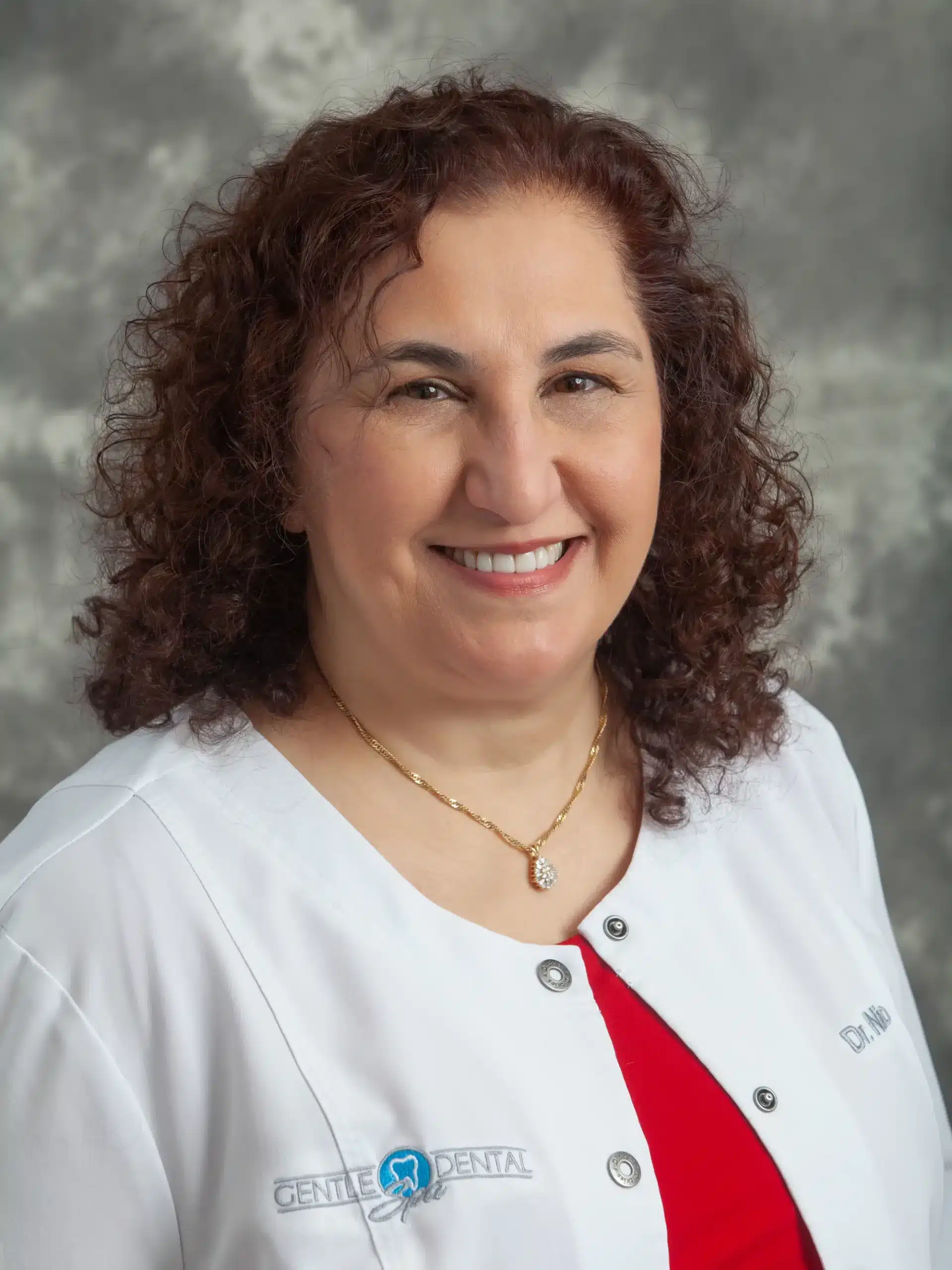 Dr. Jacqueline Niro-Kraemer smiling in her Gentle Dental Spa white coat