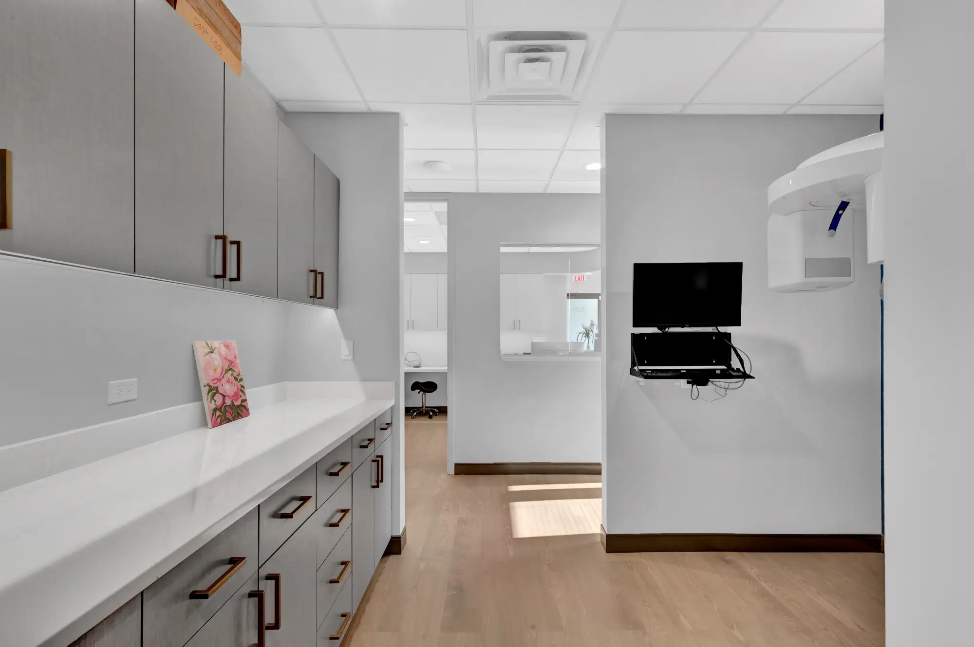 Workstation counter with grey cabinets and a wall monitor