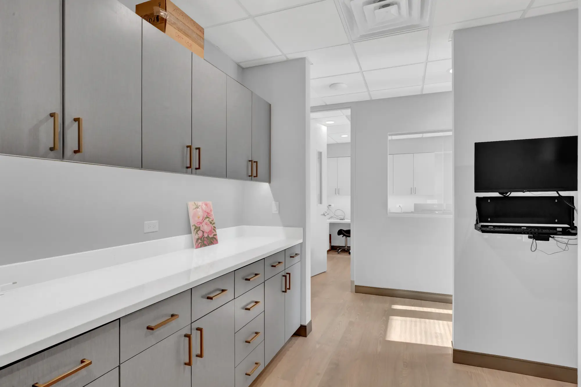 Hallway workstation with cabinets and a wall-mounted monitor