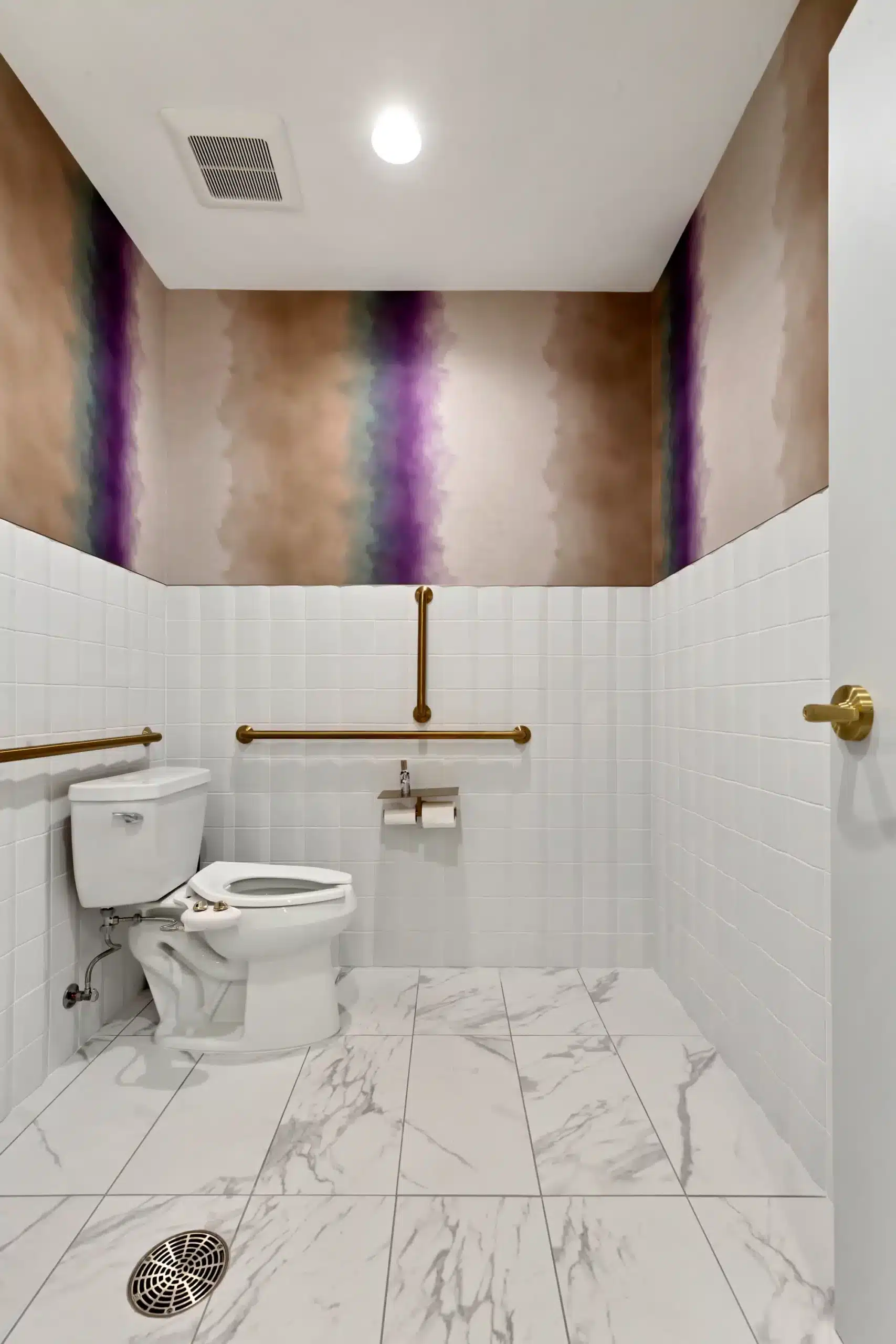 Accessible restroom with grab bars and marble floor