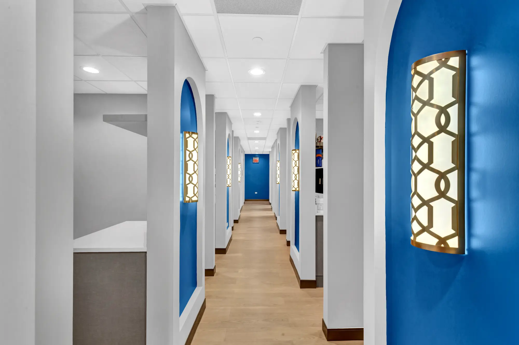 Treatment room hallway lit by decorative wall sconces