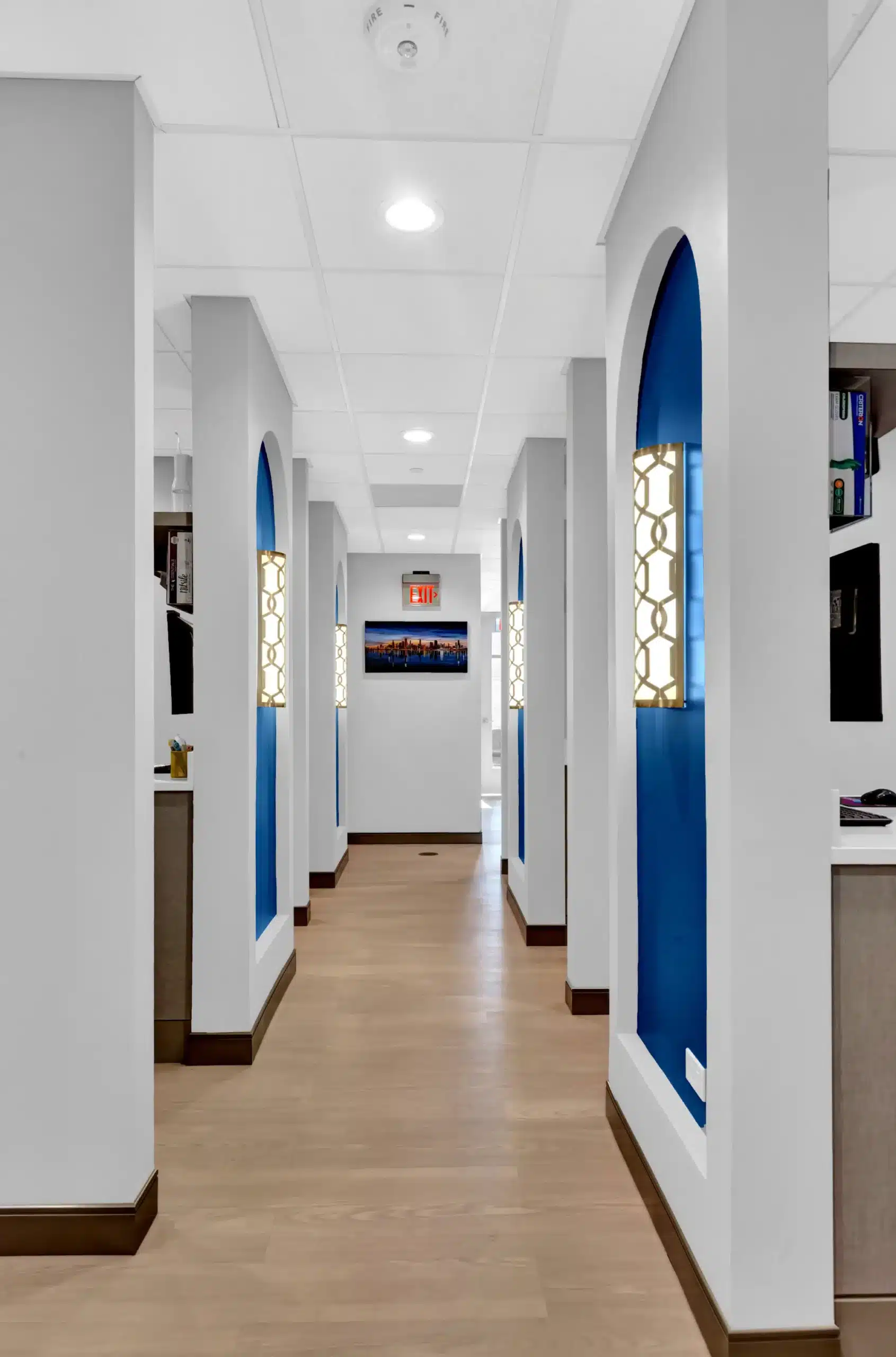 Hallway past the treatment rooms with lit wall sconces