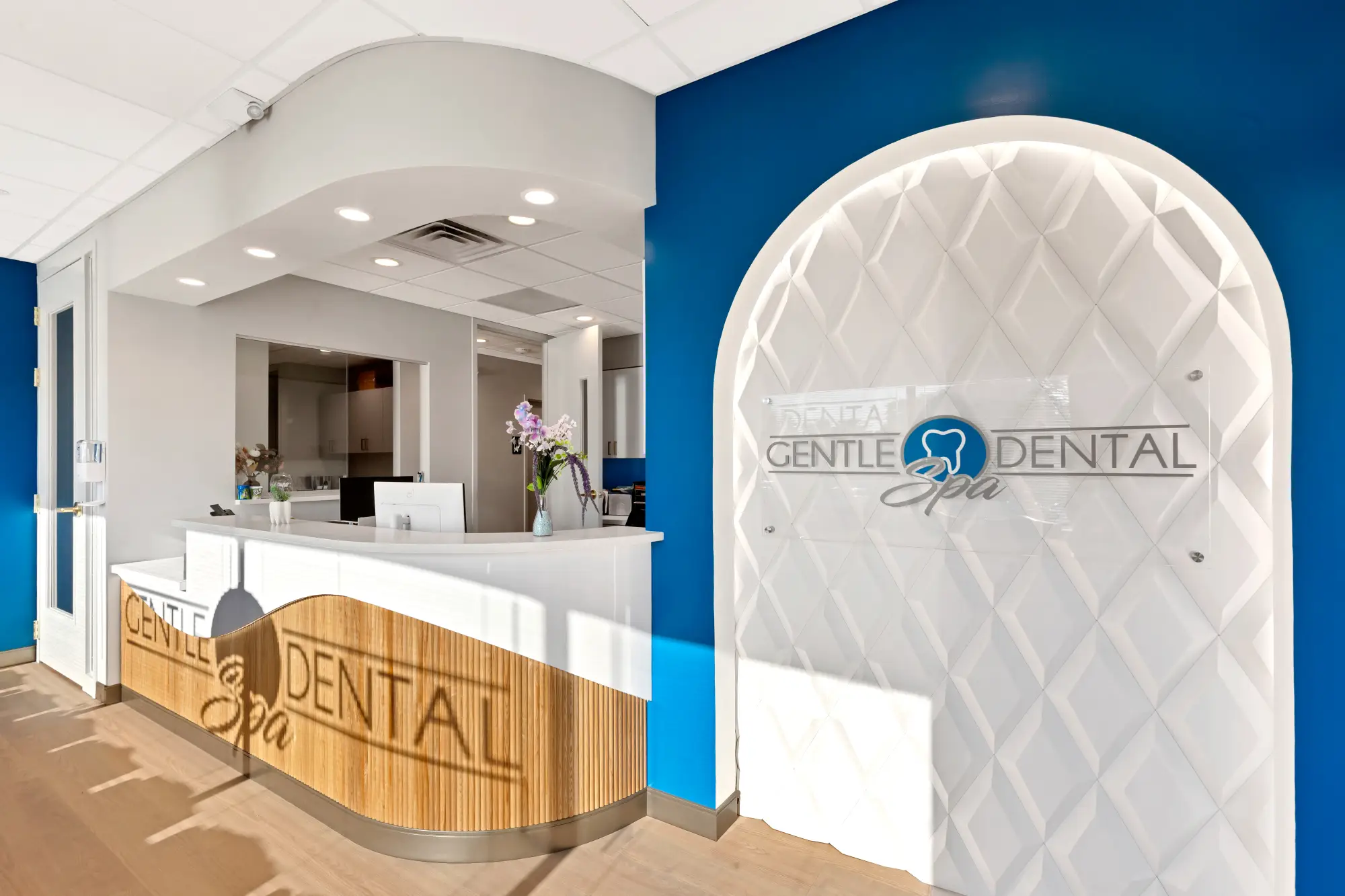Reception desk and the illuminated Gentle Dental Spa logo wall