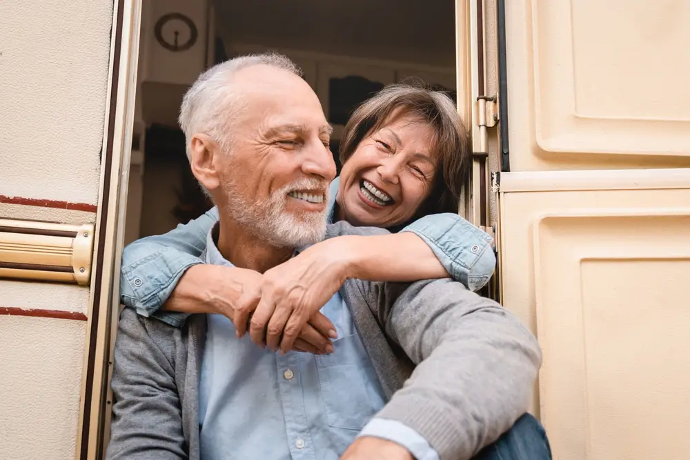 Laughing senior couple hugging in a doorway