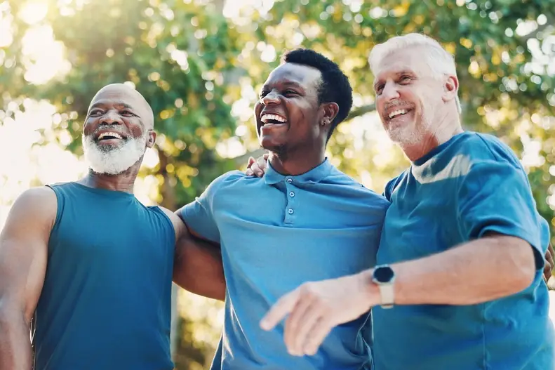 Three smiling men walking together outdoors