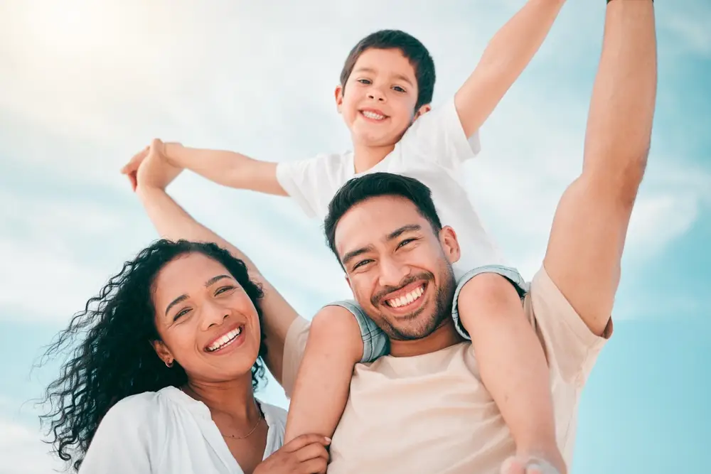 Happy family outdoors with a boy riding on his father’s shoulders
