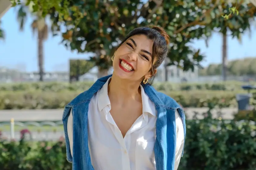 Smiling woman in a denim jacket outdoors