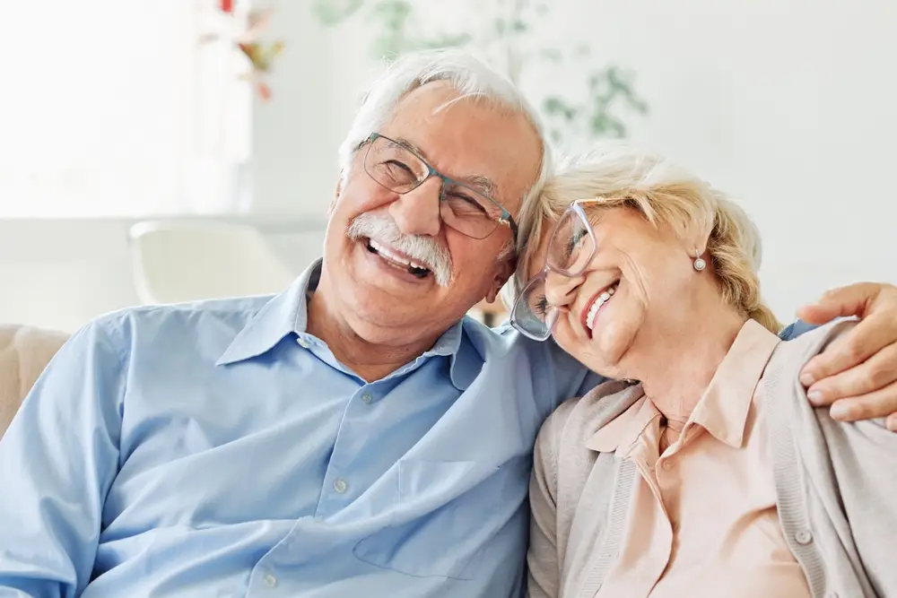 Smiling senior couple sitting close together on a sofa