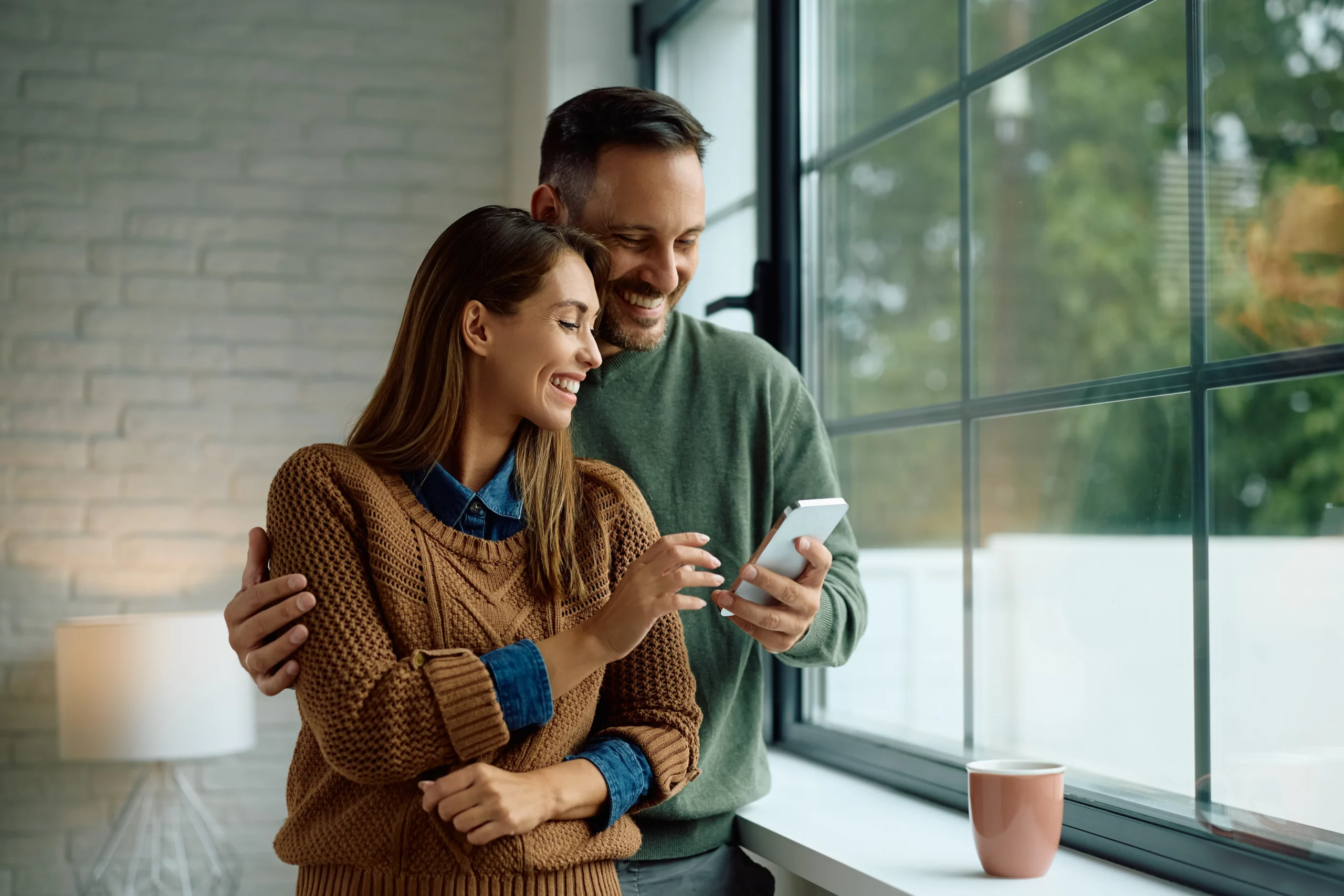 Couple at home looking at a smartphone together